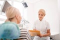 Attentive dentist writing complains of her patient.