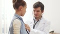 The attentive doctor listens to the lungs of a small patient with a stethoscope