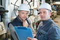 attentive factory worker writing on clipboard in factory Royalty Free Stock Photo