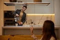 Attentive husband cooking tea for loving wife at home kitchen