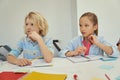 Attentive little schoolboy and schoolgirl studying and listenin to teacher, sitting together at the table in elementary Royalty Free Stock Photo