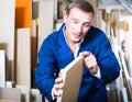 Attentive male worker standing with plywood pieces Royalty Free Stock Photo