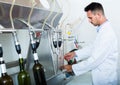 Attentive man making tests in wine manufactory laboratory