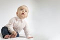 Attentive open-mouthed toddler sitting on the blanket and looking up. Copy space. Postcard