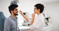 Attentive optometrist examining female patient on slit lamp Royalty Free Stock Photo
