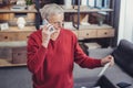 Attentive pensioner looking at the bill and calling his bank