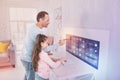 Attentive programmer looking at the screen while standing near his daughter