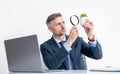attentive research investor look at plant through magnifying glass in business office Royalty Free Stock Photo
