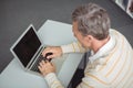 Attentive school teacher using laptop in library