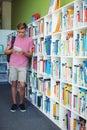 Attentive schoolboy using digital tablet in library Royalty Free Stock Photo