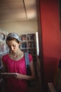 Attentive schoolgirl using digital tablet in library Royalty Free Stock Photo