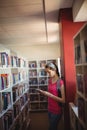 Attentive schoolgirl using digital tablet in library Royalty Free Stock Photo