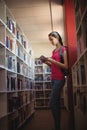 Attentive schoolgirl using digital tablet in library Royalty Free Stock Photo