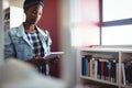 Attentive schoolgirl using digital tablet in library Royalty Free Stock Photo