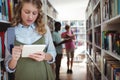 Attentive schoolgirl using digital tablet in library Royalty Free Stock Photo