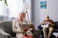 Attentive senior woman reading book in