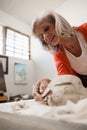 Attentive senior woman shaping a molded clay