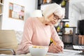 Attentive senior woman writing exercise