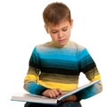 Attentive slim boy reading a thick book