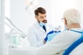 Attentive stomatologist holding false teeth in hands