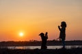 A girl in a jacket trains a guard dog of the Rottweiler breed against the backdrop of a lake and sunset Royalty Free Stock Photo
