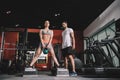 attentive trainer looking at young sportswoman