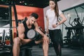 attentive trainer standing near handsome sportsman