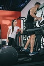 attentive trainer supervising sportsman working out