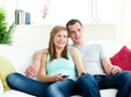 Attentive young couple watching tv on the sofa Royalty Free Stock Photo