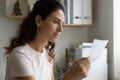 Attentive young lady engaged in reading important financial legal document