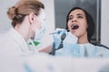 Attentive young professional stomatologist doing teeth checkup