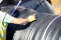 Attenuation tank made of big diameter plastic pipe delivered on construction site, offloaded and moved by an excavator into Royalty Free Stock Photo