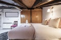 attic bedroom with sloping ceilings with vintage wooden beams, Royalty Free Stock Photo