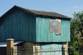 Attic of a blue rural wooden house with a boarded up window Royalty Free Stock Photo