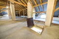 Attic of a building with wooden beams of a roof structure and a fire exit door in floor Royalty Free Stock Photo