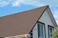 Attic house with metal roof and white plastic rain gutter Royalty Free Stock Photo