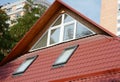 Attic house skylights with panoramic window. Metal roofing on house attic with skylights