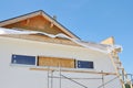 Attic insulation. House wall facade insulation, painting walls, roofing construction, installing soffits boards, fascias. House Royalty Free Stock Photo