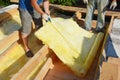 Attic insulation with mineral wool. Roofing contractor measure mineral wool insulation material for cut during attic floor