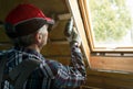 Attic insulation and renovation. Man fixing metal frame using an electric screwdriver on ceiling covered with rock wool