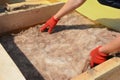 Attic Insulation. Roofer Hands Installing House Roof Thermal Insuation with Mineral Wool