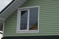 Attic of a private house with a green plastic wall and one white window Royalty Free Stock Photo