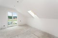 Attic room under construction with gypsum plaster boards and windows.