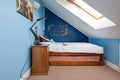 Attic style small bedroom with single bed and angle poise lamp