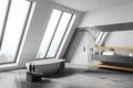 Attic white bathroom corner with tub and sink Royalty Free Stock Photo