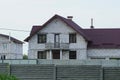 The attic of a white brick house with an open concrete balcony with windows under a red tiled roof Royalty Free Stock Photo