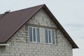 Attic of a white brick house with two windows Royalty Free Stock Photo