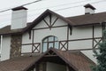 Attic of a white house with a window under a brown tiled roof Royalty Free Stock Photo