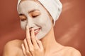 Attracitve young Asian woman applying clay mask on her facee. Spa and wellness, skin care product concept