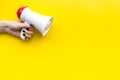 Attract attention concept. Megaphone in hand on yellow background top view copy space Royalty Free Stock Photo